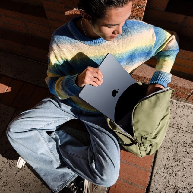 Pohled zepředu na osobu, která si dává 15palcový MacBook Air do tašky