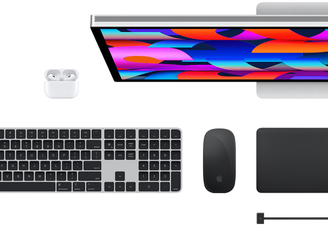 Pohled shora na vybrané doplňky k Macu: Studio Display, Magic Keyboard, Magic Mouse, Magic Trackpad, AirPods a MagSafe nabíjecí kabel